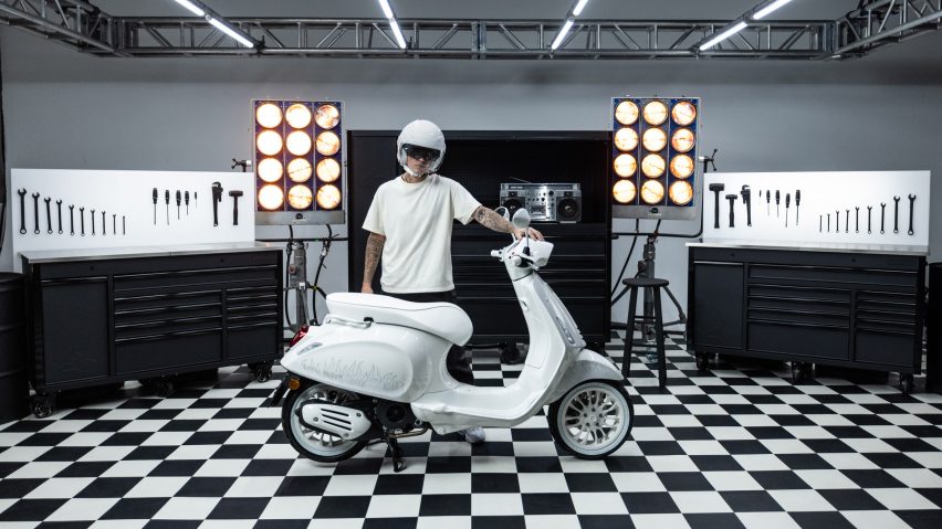 Justin Bieber in a white helmet holding a scooter he designed for Vespa