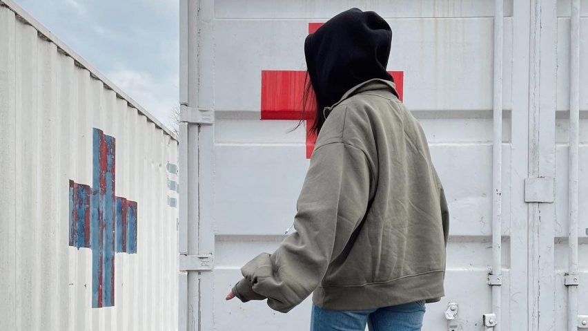 Katerina Kovalenko in front of Red Cross containers after fleeing from the Ukraine war