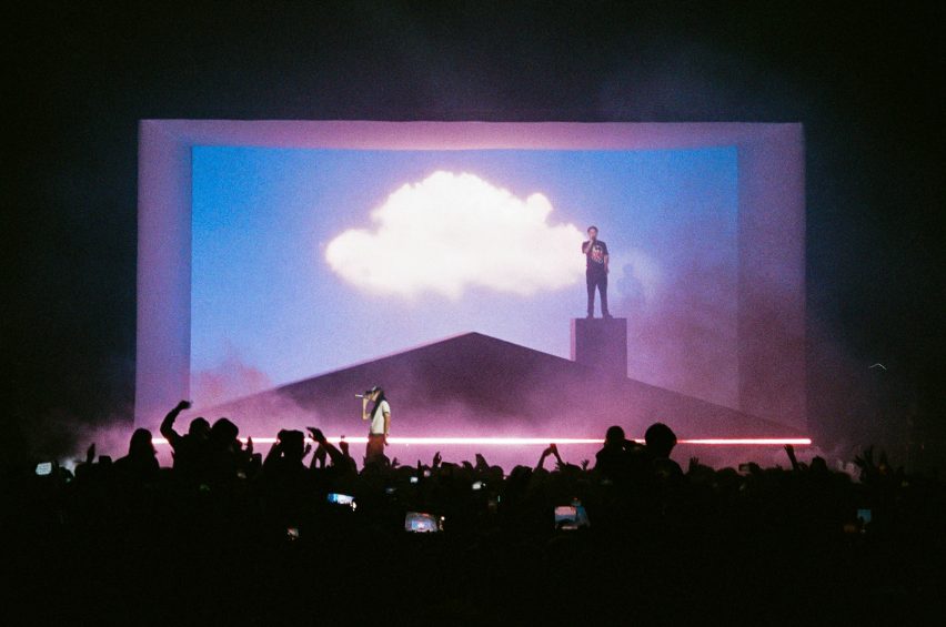 Slowthai standing on the roof of a house on stage