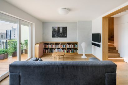 Wide view of the living space from behind a long grey sofa