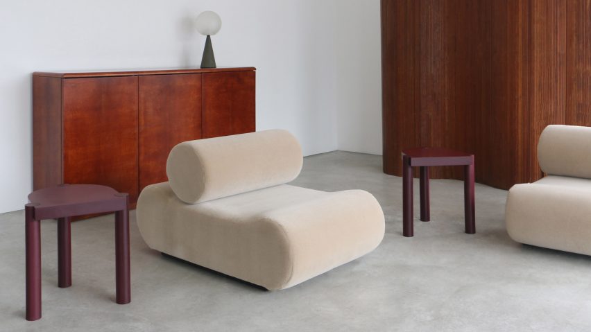 Two burgundy-coloured three legged Plod stools in a living room