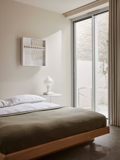 Bedroom interior of Reighton Road house with low timber bed