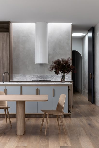 Kitchen with marble tops and wooden furniture in home by Luke Fry
