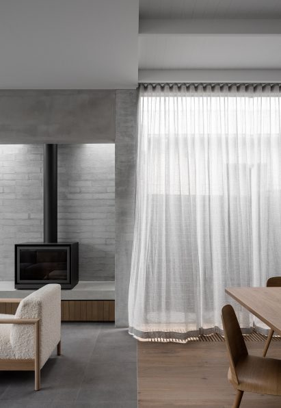 Flowing curtains and wood burner in living room interior of Ripponlea House