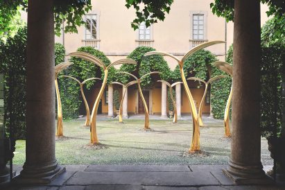 A photograph of golden olive tree sculptures