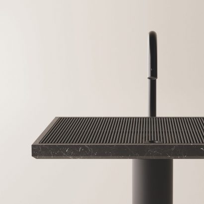 Detail of dark minimalistic sink in front of neutral backdrop