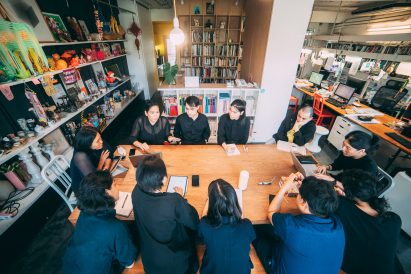 All(zone) employees sitting around a desk