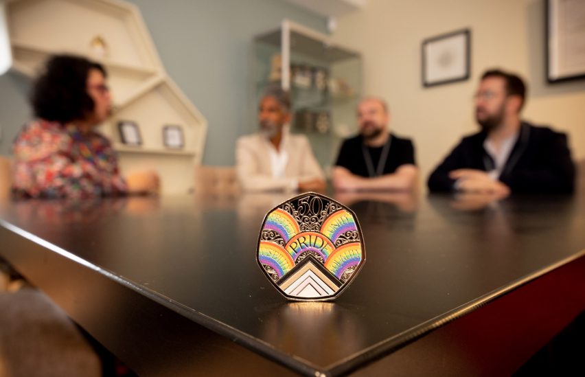 Pride in London members sitting behind a Pride 50p coin