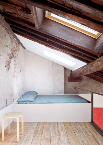 Mezzanine bedroom beneath exposed ceiling
