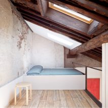 Mezzanine bedroom beneath exposed ceiling