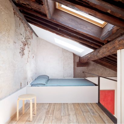 Mezzanine bedroom beneath exposed ceiling