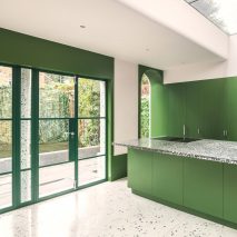 A kitchen with green painted interiors and French doors