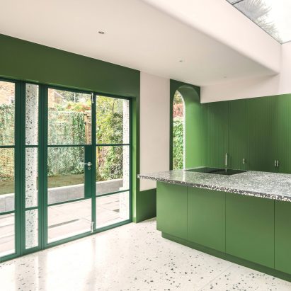 A kitchen with green painted interiors and French doors