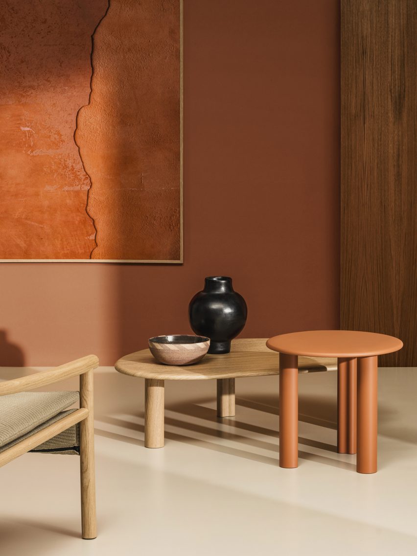 Photograph showing a burnt orange-painted room with Ghia tables in natural and red paint varieties
