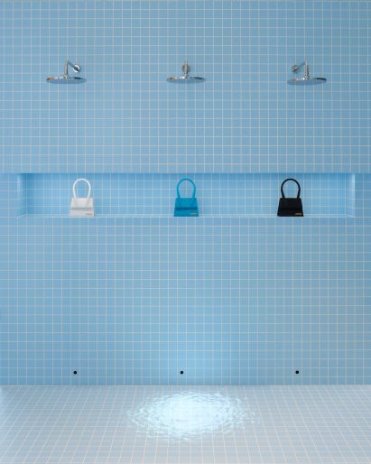 Image of a blue-tiled shower wall with Jacquemus bags at Le Bleu installation