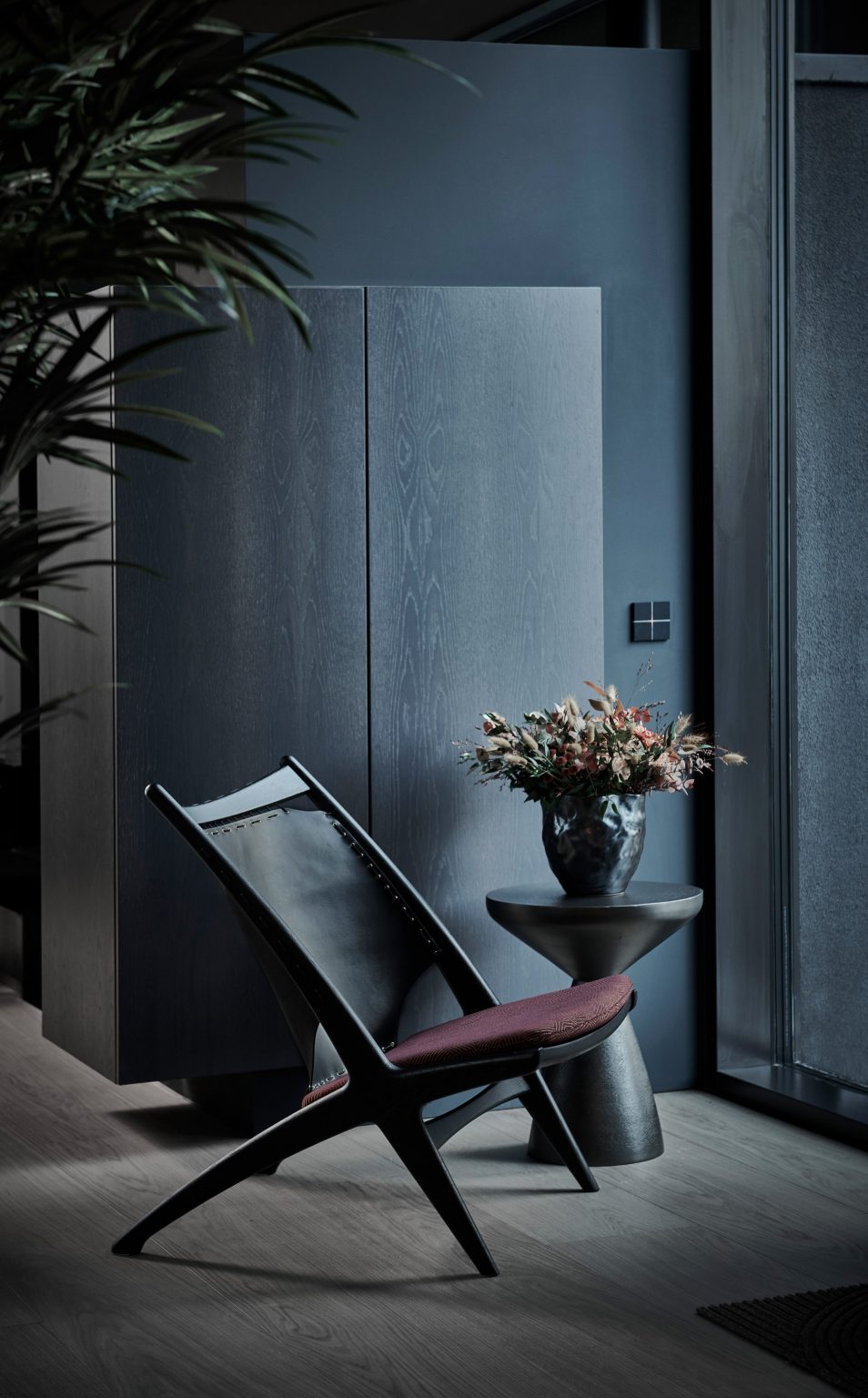 Black Krysset chair with a burgundy seat cushion in a dark room