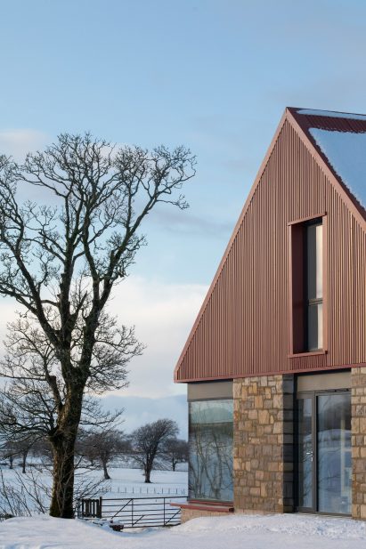 Image of the stone and metal exterior of Ceangal House in the snow
