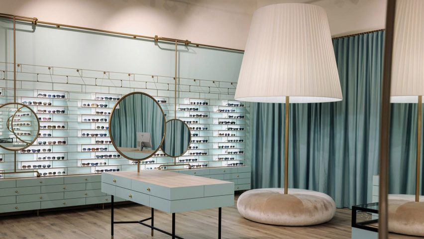 Oversized lamp and dusty pink pouf next to baby blue storage in Morela eyewear store in Ljubljana, Slovenia, designed by Nika Zupanc