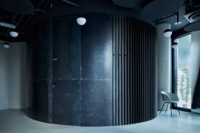 An image showing the dark-toned, curved cement wall of the doctors' office