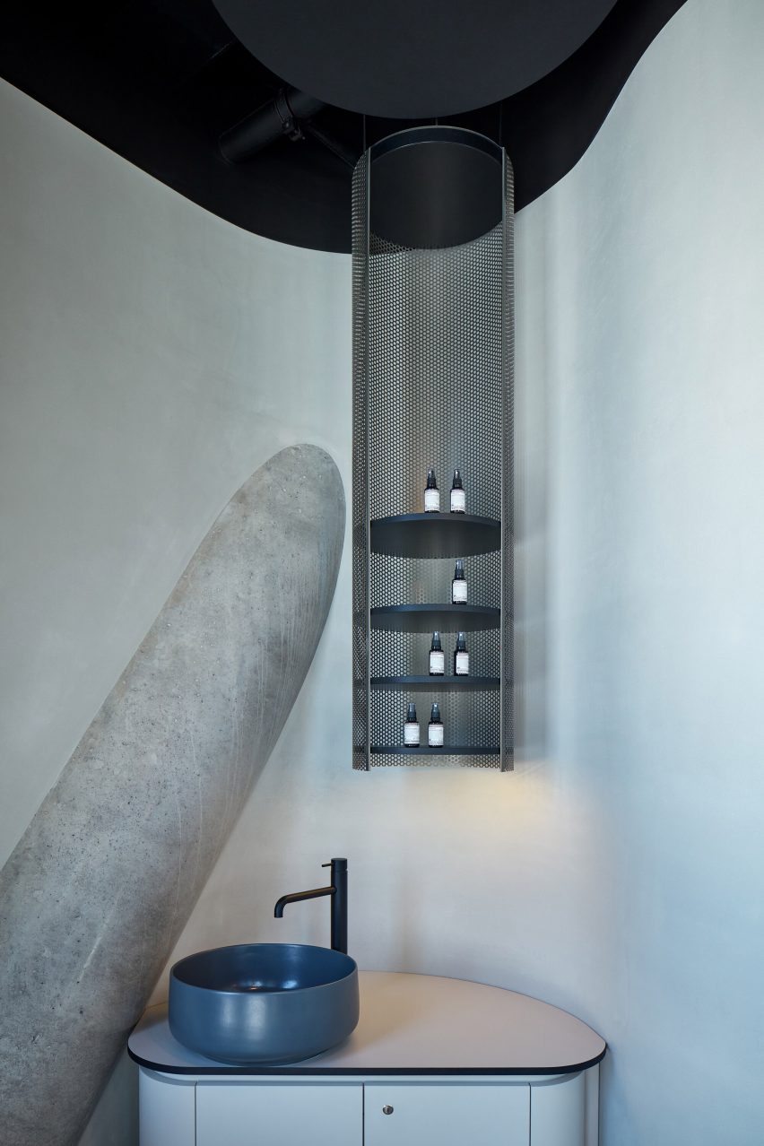 The lighter interior inside the office with structural columns visible as well as storage and sink