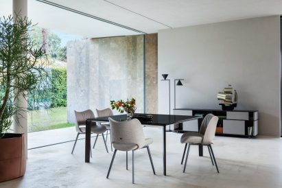 Nice chairs by Poltrona Frau around the Homey table in a concrete room with floor to ceiling glass window