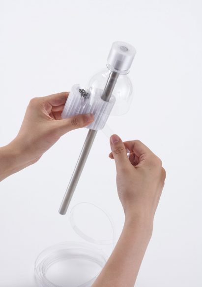 Hands slicing a plastic bottle using stacked bearings