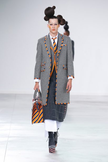 Image of a model wearing grey tailoring walking down the Thom Browne runway