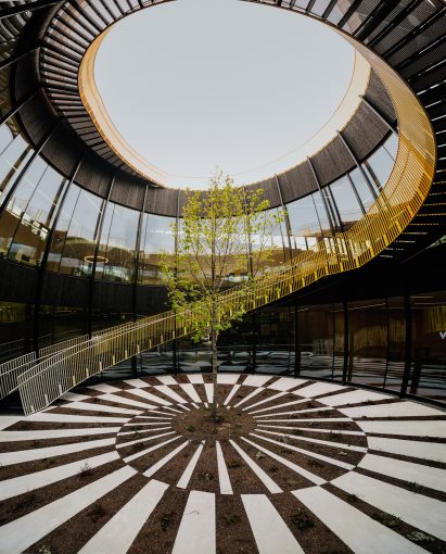 Courtyard with yellow spiral staircase in The Plus furniture factory by BIG 