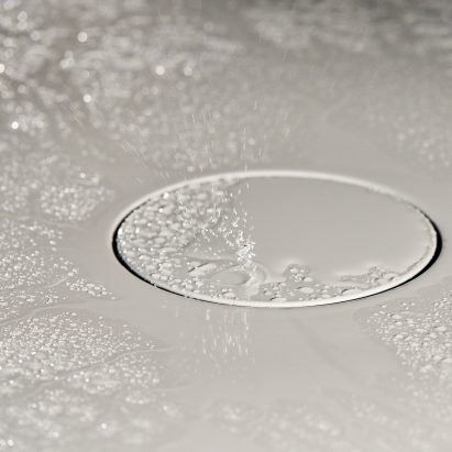 Closeup shot of shiny white bathroom surface with water droplets