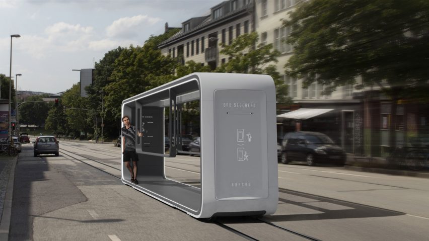 Abacus tram in light grey travelling with passenger travelling through town