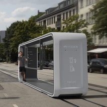 Abacus tram in light grey travelling with passenger travelling through town