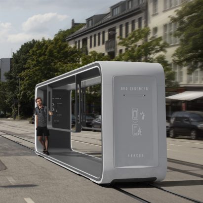 Abacus tram in light grey travelling with passenger travelling through town
