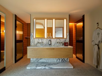 Bathroom with warm-toned lighting and marble surfaces in Ace Hotel Sydney