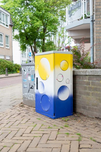 Large yellow, white and blue box on a street corner