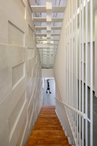 Wood and metal staircase against stone wall