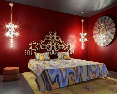 A bed covered in a swirling patterned bedspread