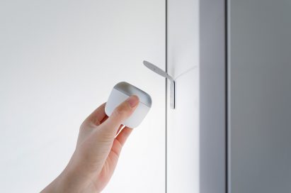 A photograph of someone holding the Butlr device