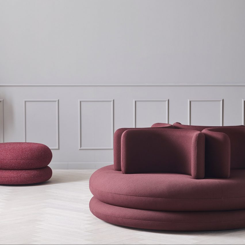 Photograph showing panelled room with burgundy-coloured sofa and pouf