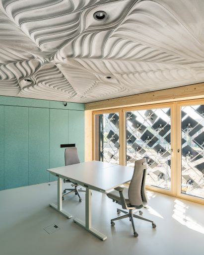 Contoured concrete slab celing above an office space