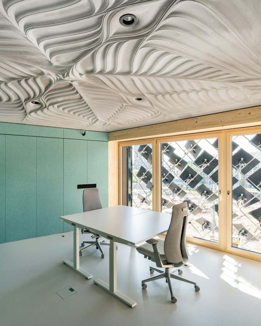 Contoured concrete slab celing above an office space