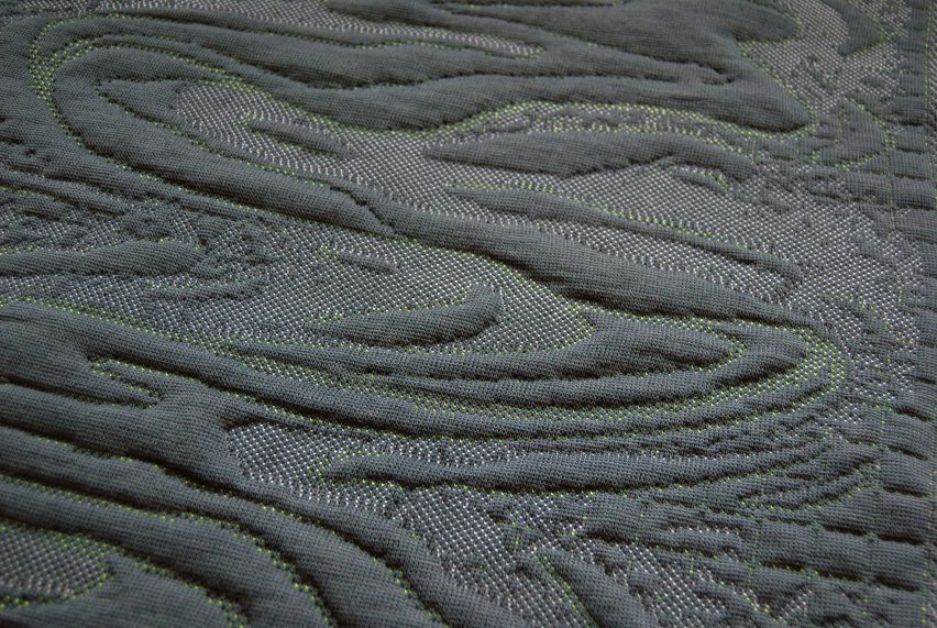 A blue fabric with embossed swirls