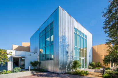 Corrugated metal facade with punched windows 