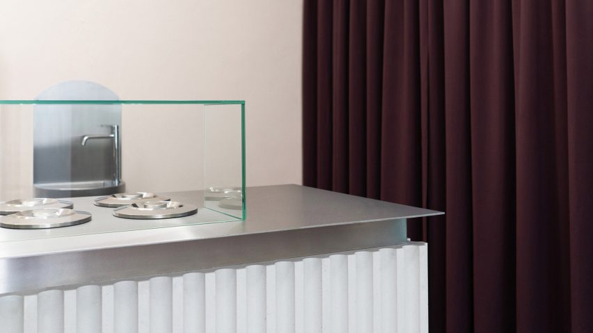 Steel and concrete serving counter next to deep aubergine-coloured curtain in Ještě Jednu ice cream shop in Brno by Holky Rády Architekturu