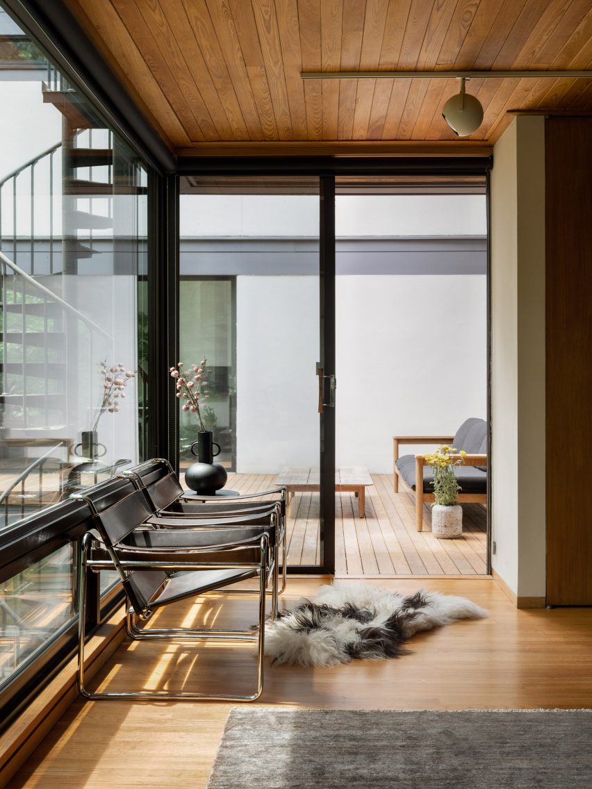 Hallway with modernist chairs leading to deck
