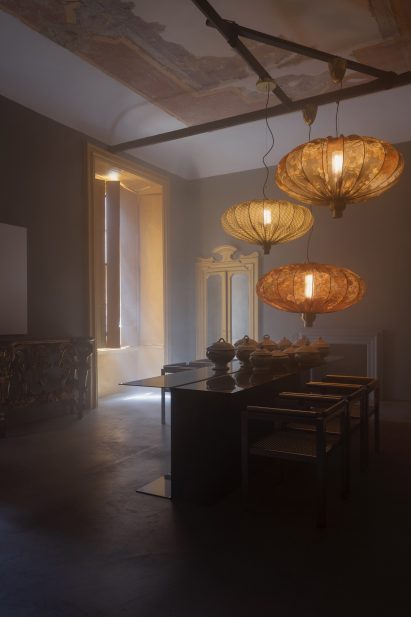 Three large hanging lights and a table inside Oublie