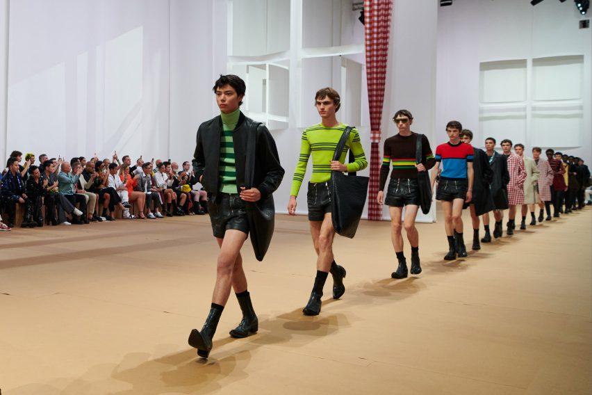 Models are pictured walking across the paper set at the Prada Spring Summer 2023 show