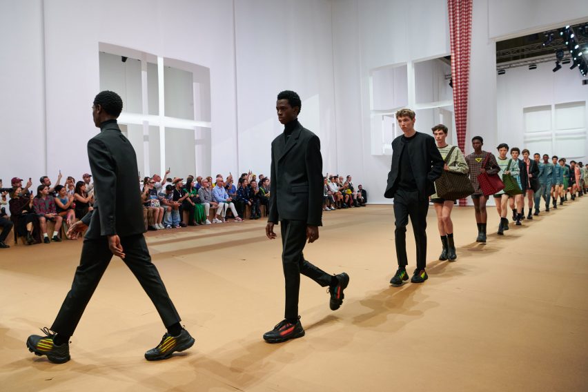 Models are pictured walking across the paper set at the Prada Spring Summer 2023 show