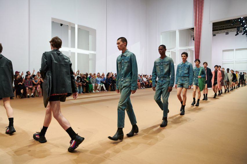 Models are pictured walking across the paper set at the Prada Spring Summer 2023 show
