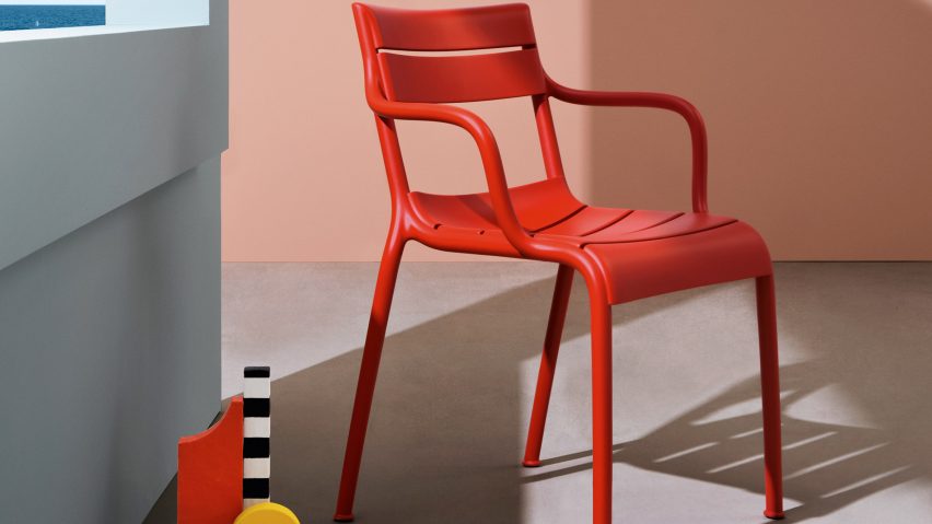 Souvenir armchair in red set against a pink and grey backdrop