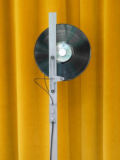 A silver vinyl player with a record